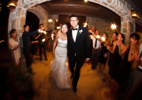 bride and groom leaving wedding through sparklers