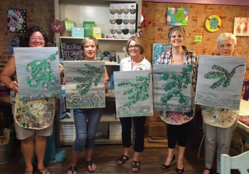 group of people holding paintings