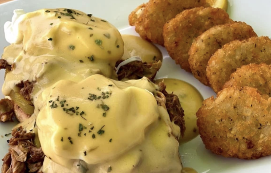 Eggs Benedict and potatoes on plate