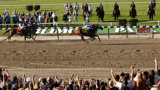 People cheer as horses take part in the Belmont Stakes race on Long Island