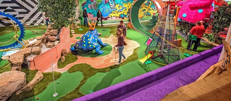 Children play on an indoor miniature golf course at Can Can Wonderland