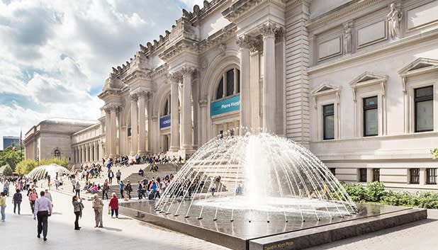 People walking past the fountain and entrance to the metropolitan museum of art