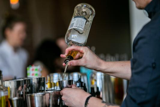Bartender pours shot into shot glass