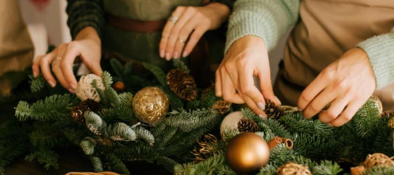 Two people making Christmas wreaths