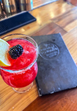 Close-up of pink mocktail and menu placed on bar at Mountain Madre