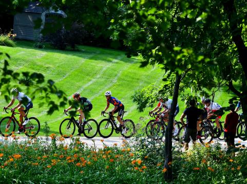 Cyclists in race on street being seen through trees
