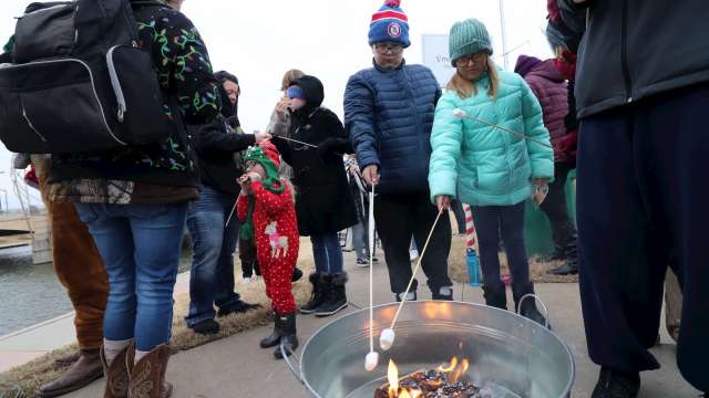 Families roast marshmallows over a bonfire in Old Town