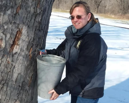 Park Naturalist Sarah Wolf tapping sugar maple trees at McCloud Nature Park ahead of Maple Syrup Days. (Photo courtesy of Hendricks County Parks & Recreation)