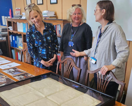3 women looking at the Declaration held at the records office in a glass case