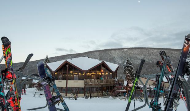 Skis standing up in the snow in front of the Bristol Mountain Lodge