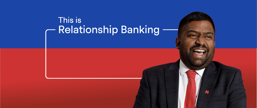 Man in navy suit with metro pin smiling and laughing