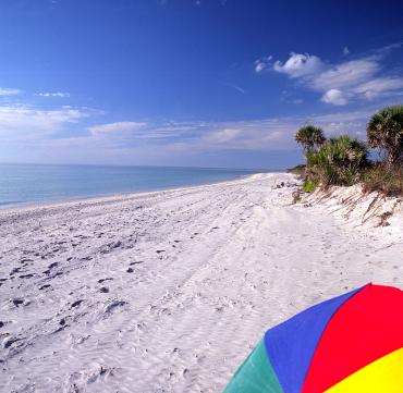 Primary colored umbrella on the pristine beach of Don Pedro Island in Punta Gorda/Englewood Beach