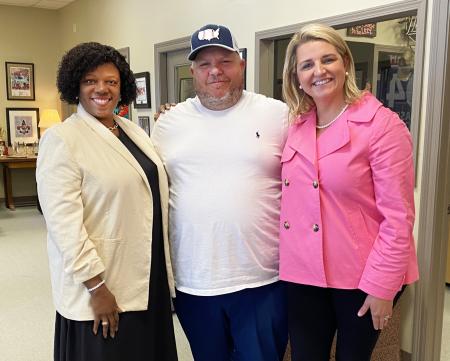 Podcast hosts Zondra and Katie stand on either side of restaurateur Patrick Heim.