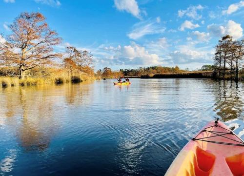 view of open fresh water from kayaker's perspective with another kayaker in view in the distance