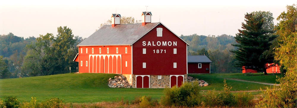 Exterior view of the red barn at Salomon Farm Park, with white text on the barn that says Salomon 1871