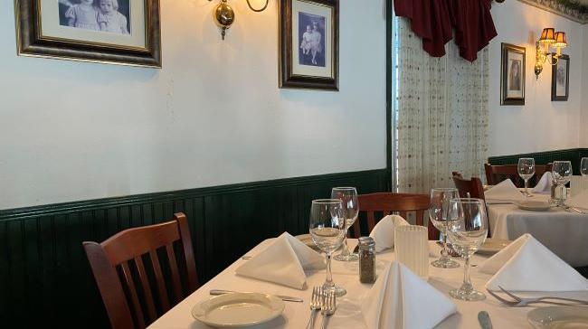 Dining room with green walls and photo frames