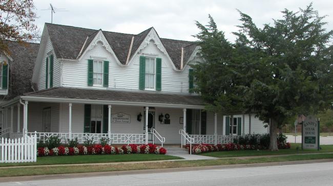 Front of a white house with green shutters