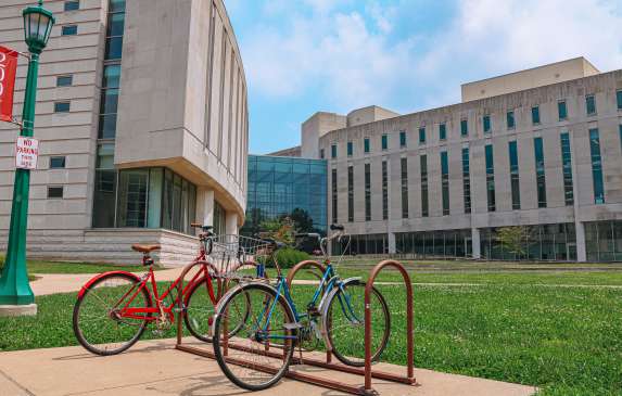 Two bikes parked at a rack outside of the Global & International Studies  Building