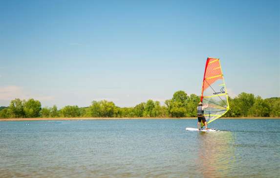 A man windsurfing on Monroe Lake