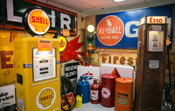 A booth full of vintage car signs and fuel pumps