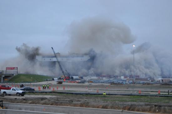 Texas Stadium imploded with smoke and dust all around and safety officers looking on