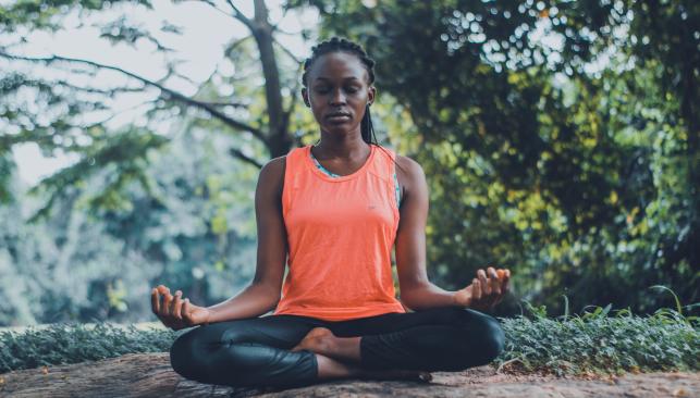 Woman doing yoga in the lotus position outdoors in Chesapeake VA