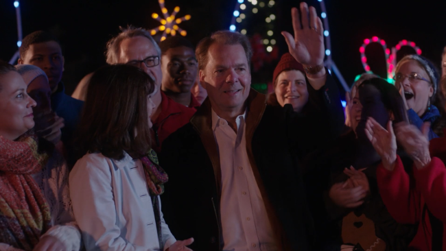 A man waving in front of a crowd of people.