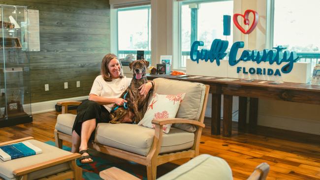 Volunteer dog walker and dog sitting and relaxing on the couch at the WElcome Center