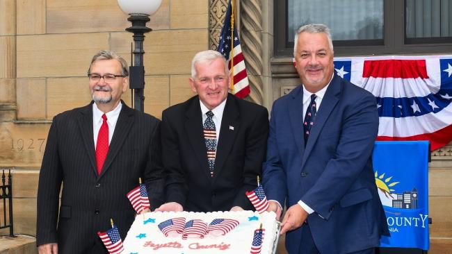 Commissioners pose with patriotic cake