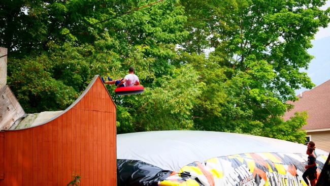 Alpine Adventures BigAirBag Stuntzone - Man on Inner Tube Soaring Through the Air