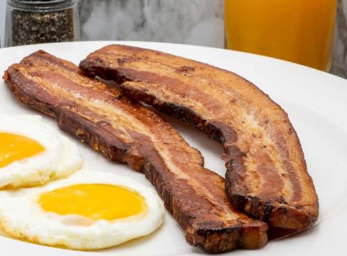 Half-inch thick slices of bacon are paired with eggs for the Original Pancake House's Bacon Steak n’Eggs breakfast.