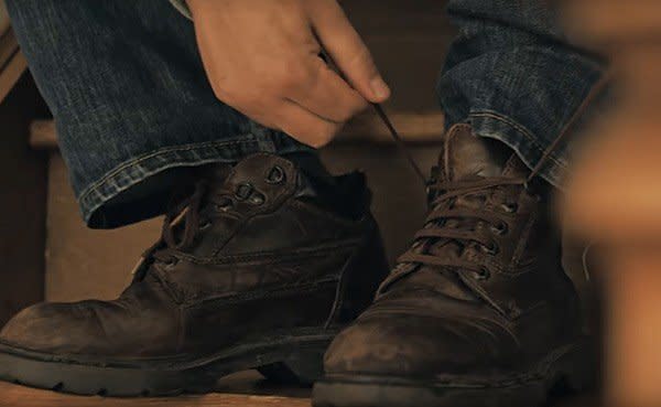A close up or someone doing up the laces on a pair of walking boots.