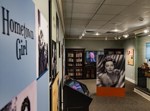 A view of the Ava Gardner Museum Library room with bookcases and glass case exhibits.