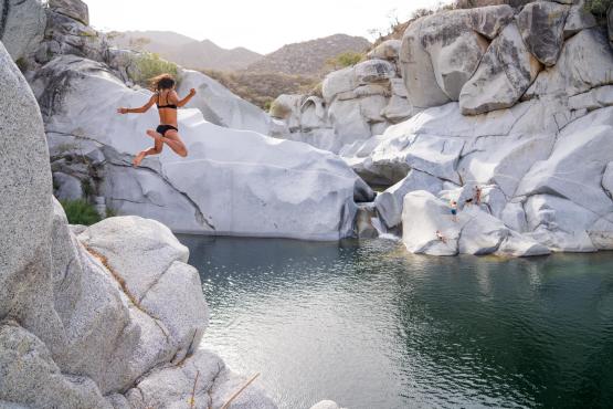 mujer saltando a lago en sierra de la laguna