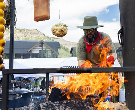 Man cooking meat on an open flame