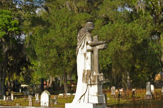 An angel statue serenely watches over the historical graves found at Oak Grove Cemetery in Brunswick, GA. Photo by Troup Nightengale.