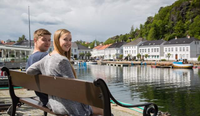 Couple relaxing next to the Risør harbour Norway