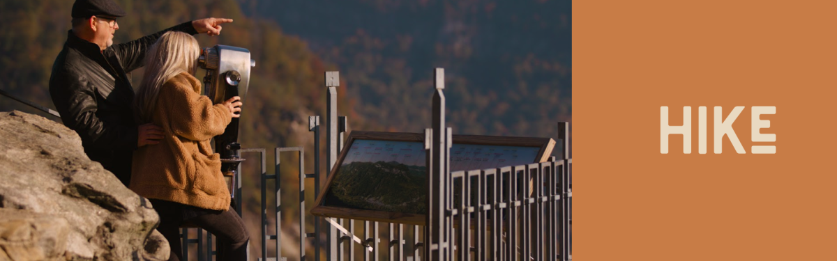 A couple of people at a scenic lookout admiring the fall colors amongst the trees in Rutherford County, NC. 