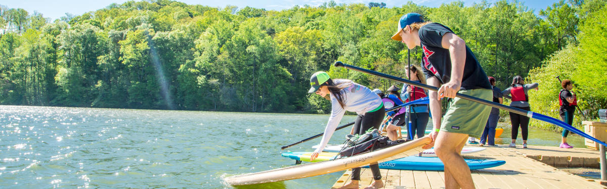 People placing their paddles in the water at High Country Paddle Shack