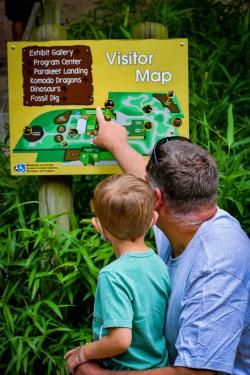 Picture of Father with son beside him pointing at a visitors map at Reptiland