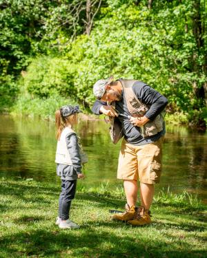 Father getting a fish off the line for his daughter