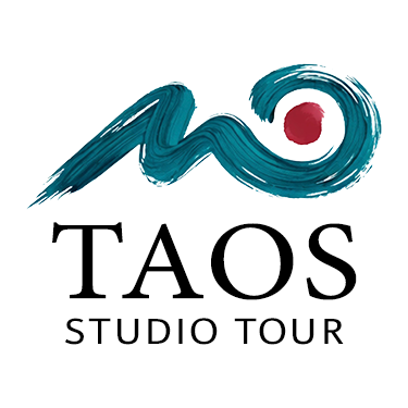 A logo for Taos Studio Tour featuring an abstract minimalist mountain and sunset design