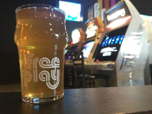 Photo of beer in front of arcade games at Free Play Arlington