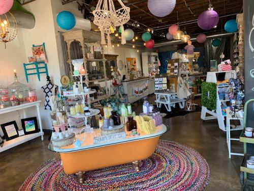 Quirky interior of Oli + Meg, featuring colorful hanging lanterns, funky chandelier, and a vintage claw-footed bath tub as a display.