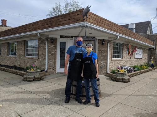 Couple in masks standing in front of Geraldine's Kitchen