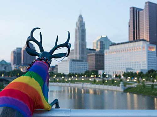Sculpture Of A Deer In A Rainbow Sweater Looking At The City Of Columbus