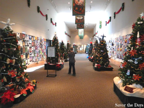 A visitor enjoys the many different decorated trees on display at the Irving Arts Center.