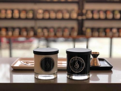 Two candle jars sit on a table with a scent infuser at Olfactory Scent Studio