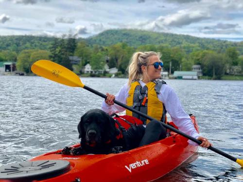 Woman and dog kayaking through lake george