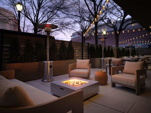 An outdoor patio at the Sonesta White Plains with a firepit and cushioned chairs.